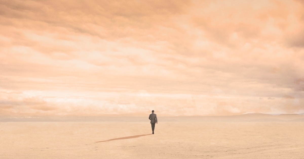 Silhouette of Man Walking On Empty Plain