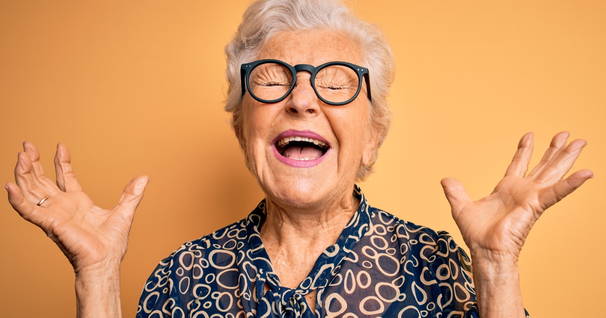 Senior Woman With Eyes Closed & Hands in Air